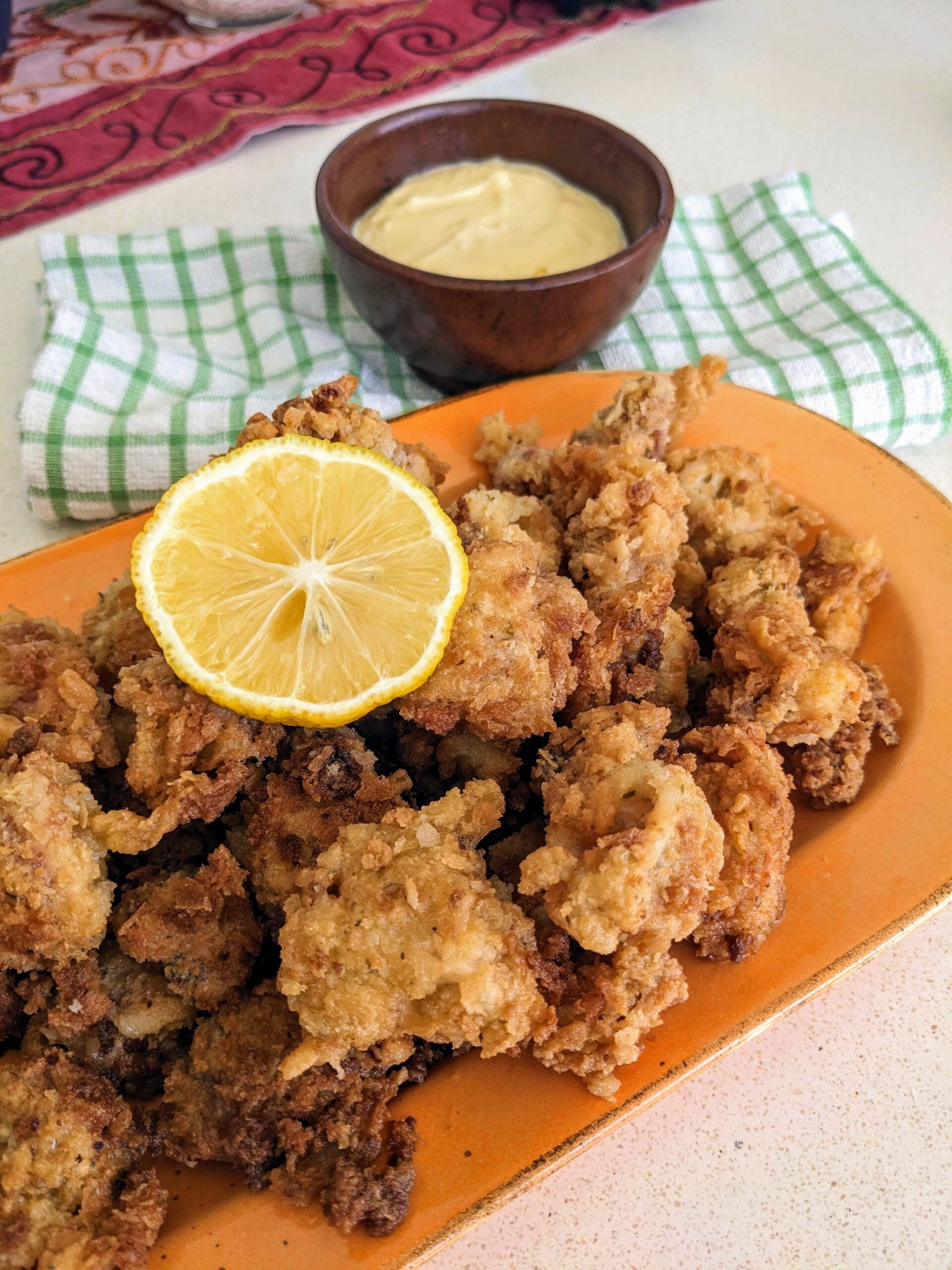 cumi tepung goreng disajikan diatas piring dengan saus mayo dan lemon