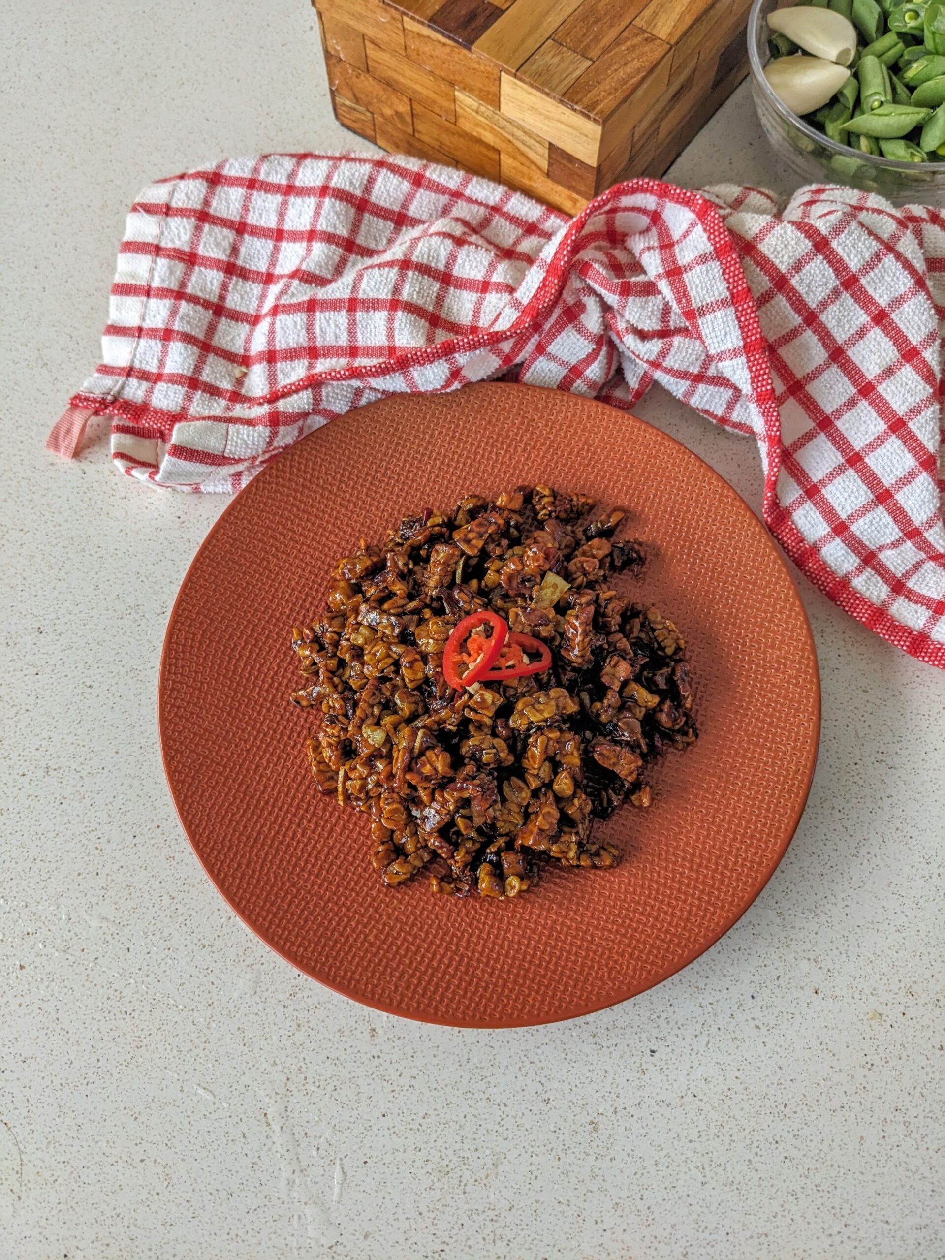 Tempe orek disajikan diatas piring berwarna oranye