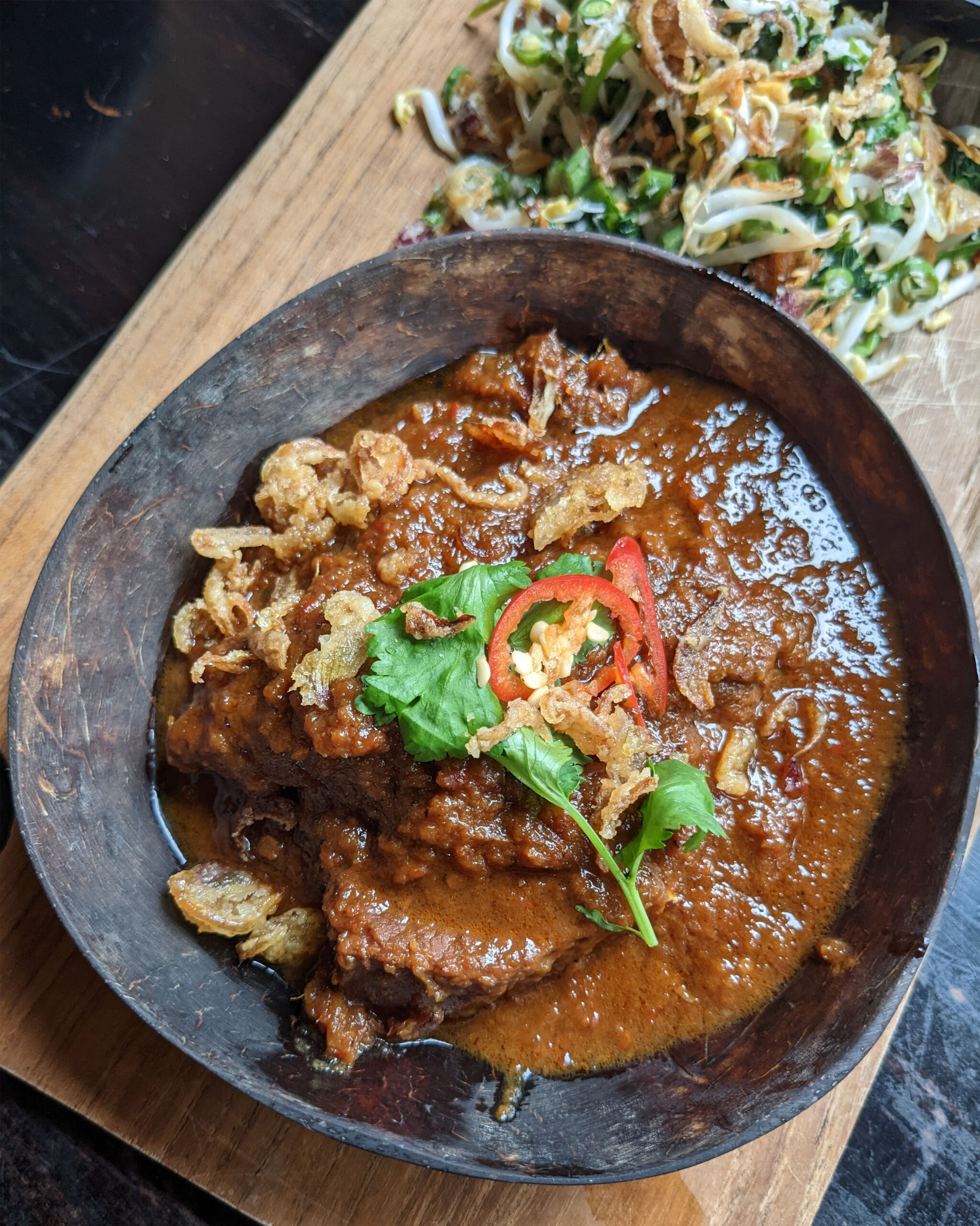 varian rendang sapi yang terkenal disajikan dimangkuk yang terbuat dari batok kelapa