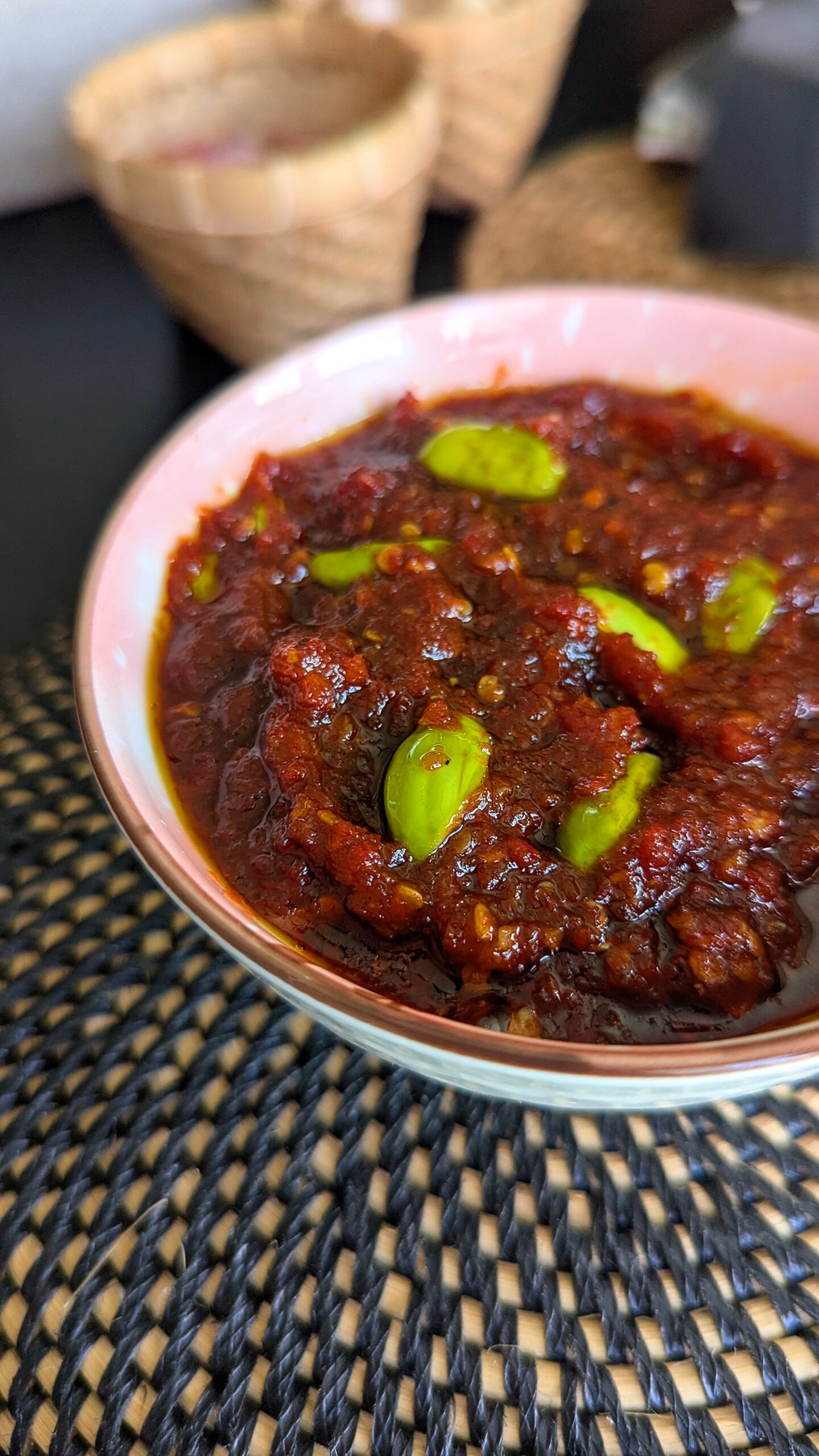Sambal petai dengan warna merah gelap yang disajikan dengan mangkuk kecil